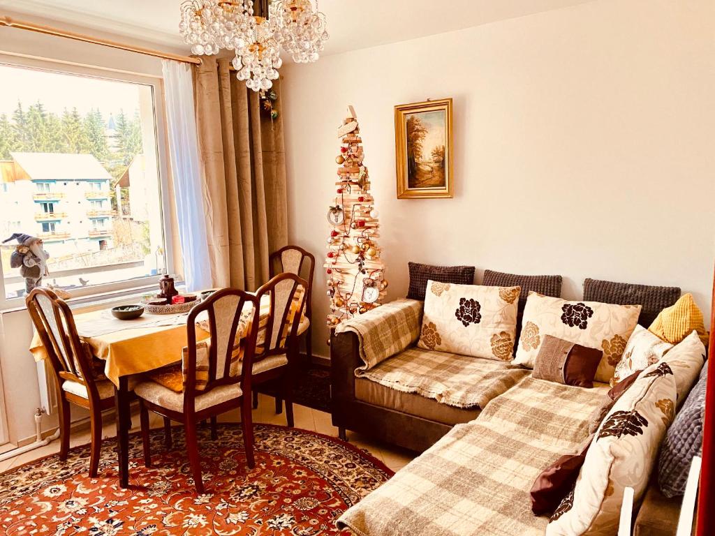 una sala de estar con un árbol de Navidad y un sofá en apartament Durau en Durau