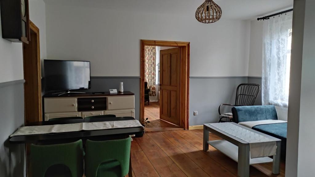 a living room with a couch and a tv at Stare Dechy in Wschowa