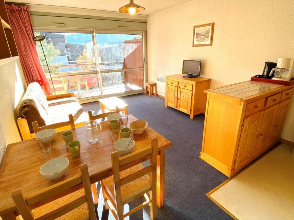 a living room with a wooden table and a kitchen at Studio Les Deux Alpes, 1 pièce, 4 personnes - FR-1-516-172 in Les Deux Alpes