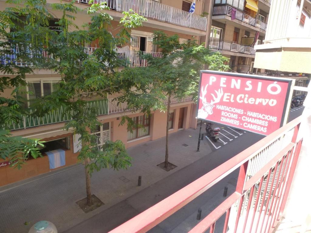 un cartel en un balcón frente a un edificio en Pension El Ciervo, en Lloret de Mar