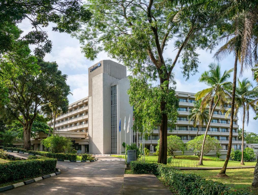 an office building with trees in front of it at Radisson Blu Mammy Yoko Hotel in Freetown
