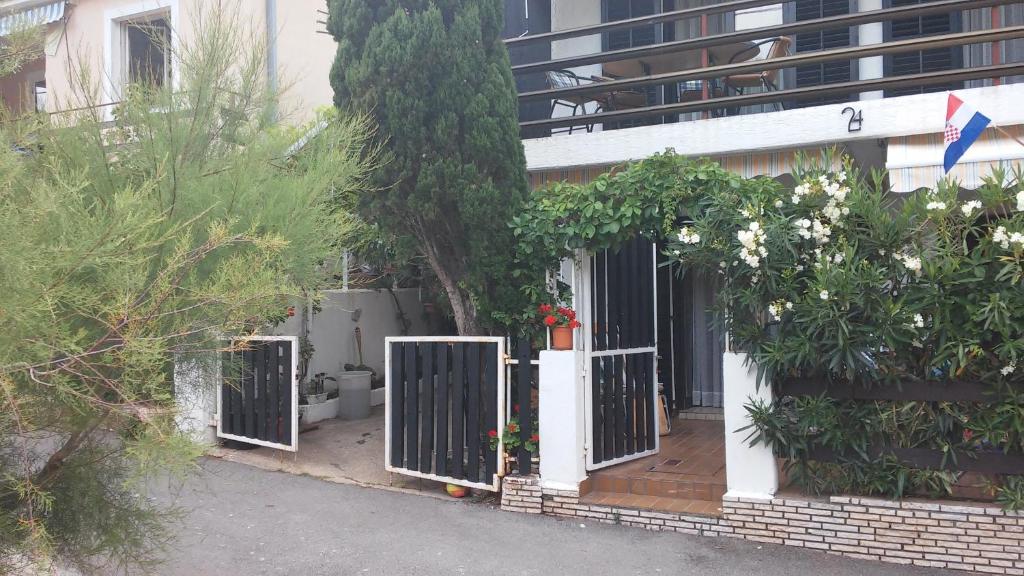 a house with a gate in front of a building at Apartments Krpan in Donja Klada