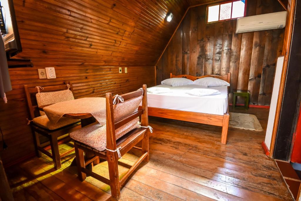 - une chambre avec un lit et une table dans l'établissement Hotel Fazenda Bavaria, à São Lourenço