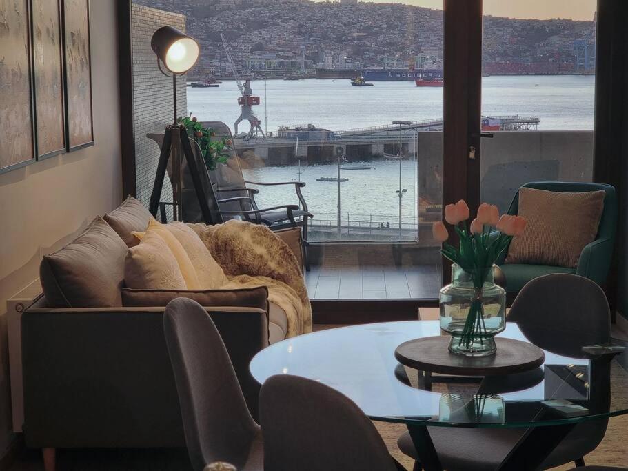 un soggiorno con tavolo e vista sul porto di Nuevo Departamento Vive Barón Valparaíso a Valparaíso