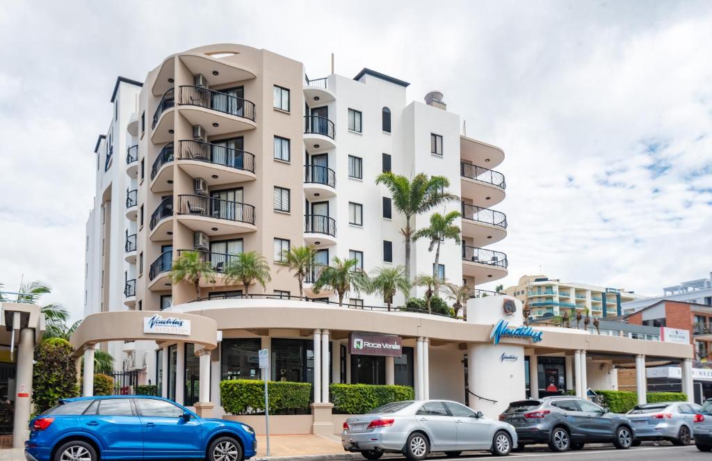 un edificio con coches estacionados frente a él en Nautilus Resort Mooloolaba en Mooloolaba