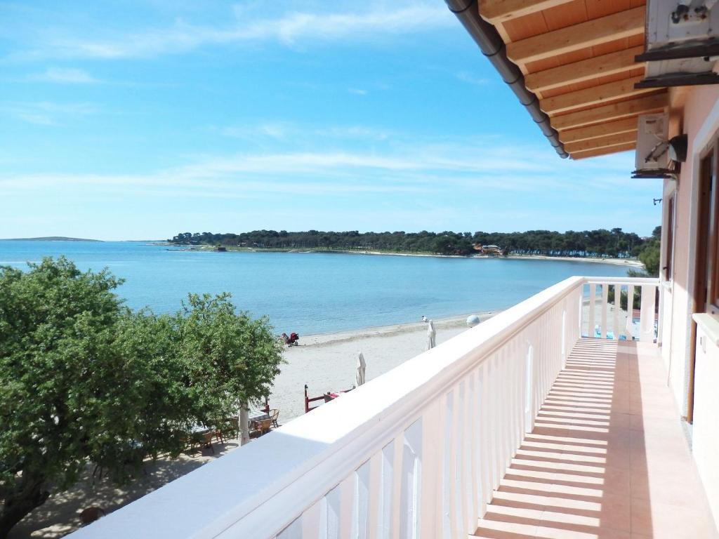 einen Balkon mit Blick auf den Strand in der Unterkunft Apartments Real - 10 m from sea in Medulin