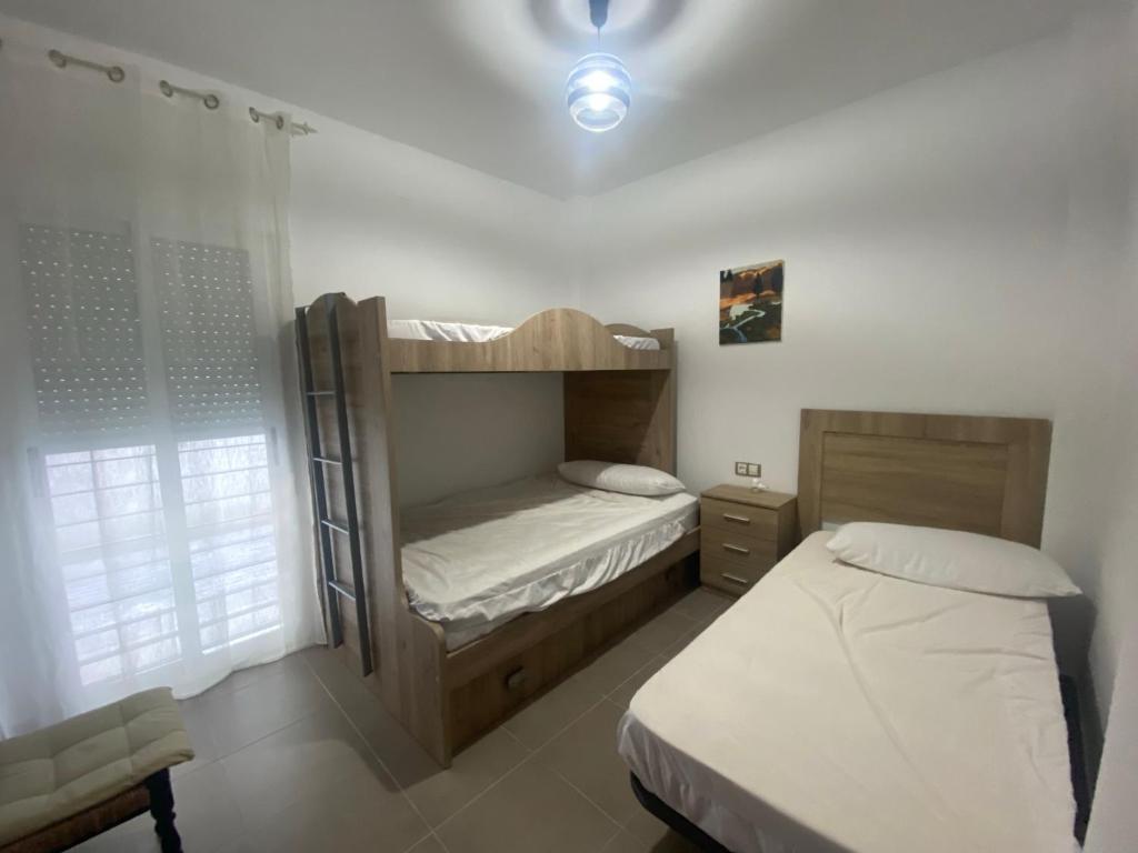 a bedroom with two bunk beds and a window at Casa Rural Cascadas del Hueznar in San Nicolás del Puerto