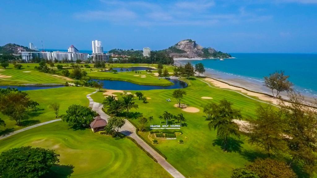 ホアヒンにあるSeapine Beach Golf and Resort Hua Hinの海とゴルフコースの空中ビュー