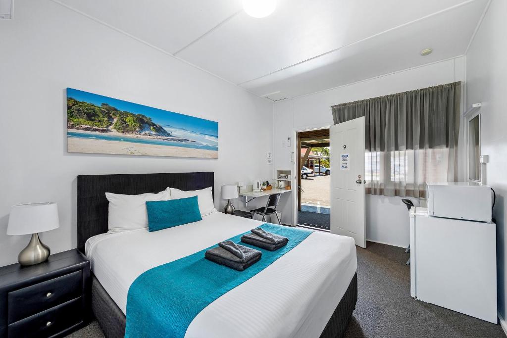 a bedroom with a bed and a desk in a room at Port Macquarie Motel in Port Macquarie