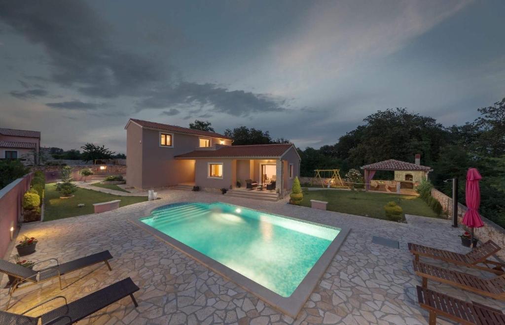 a swimming pool in the backyard of a house at Villa Klo - with pool in Valtura