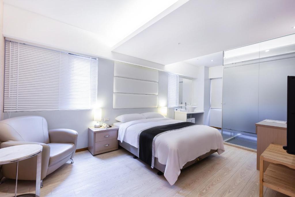 - une chambre blanche avec un lit et une chaise dans l'établissement Stay Inn 2, à Taipei