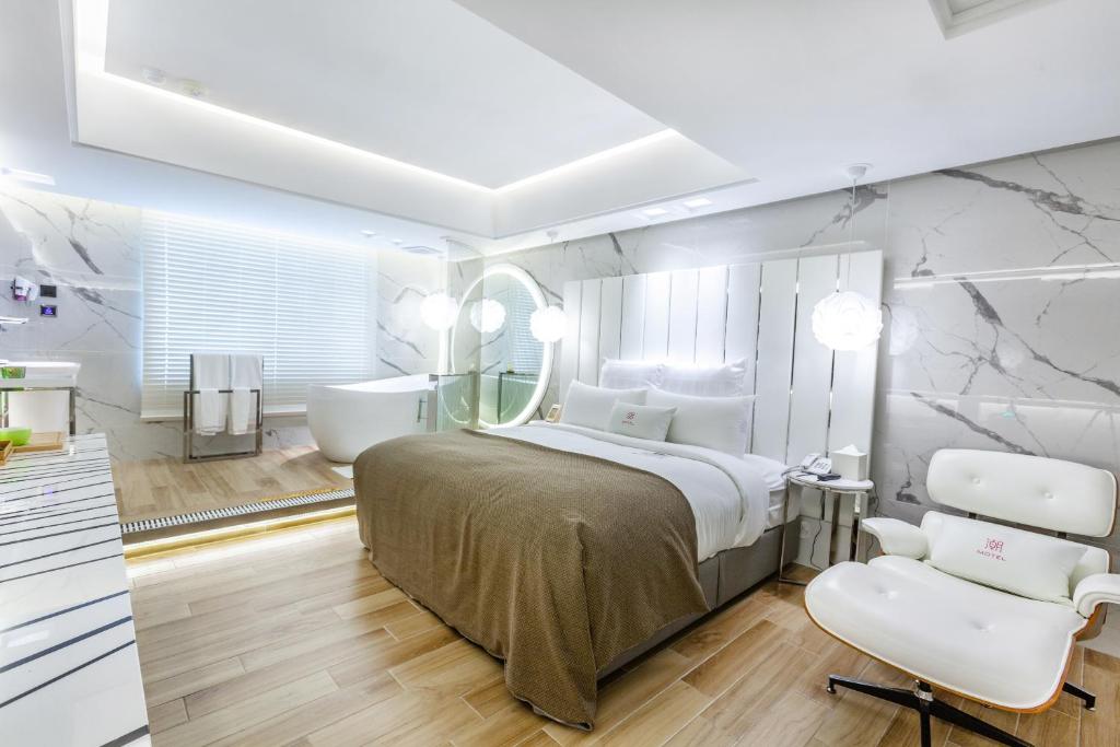 Schlafzimmer mit einem Bett, einer Badewanne und einem Waschbecken in der Unterkunft Chao Motel in Taoyuan