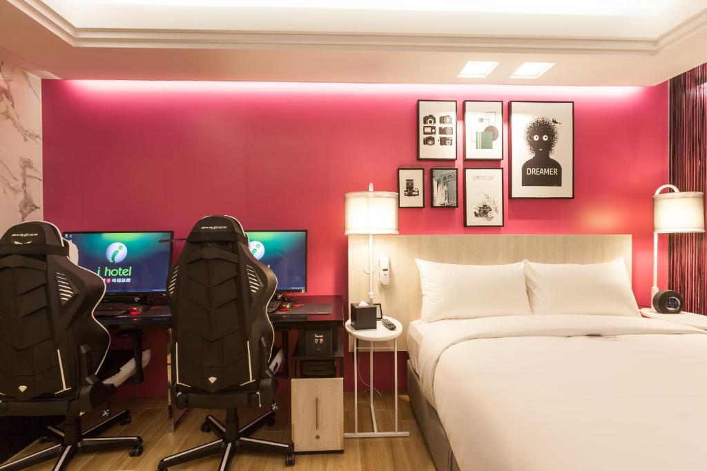 a bedroom with a bed and two desks and two monitors at i hotel 中壢館 in Zhongli