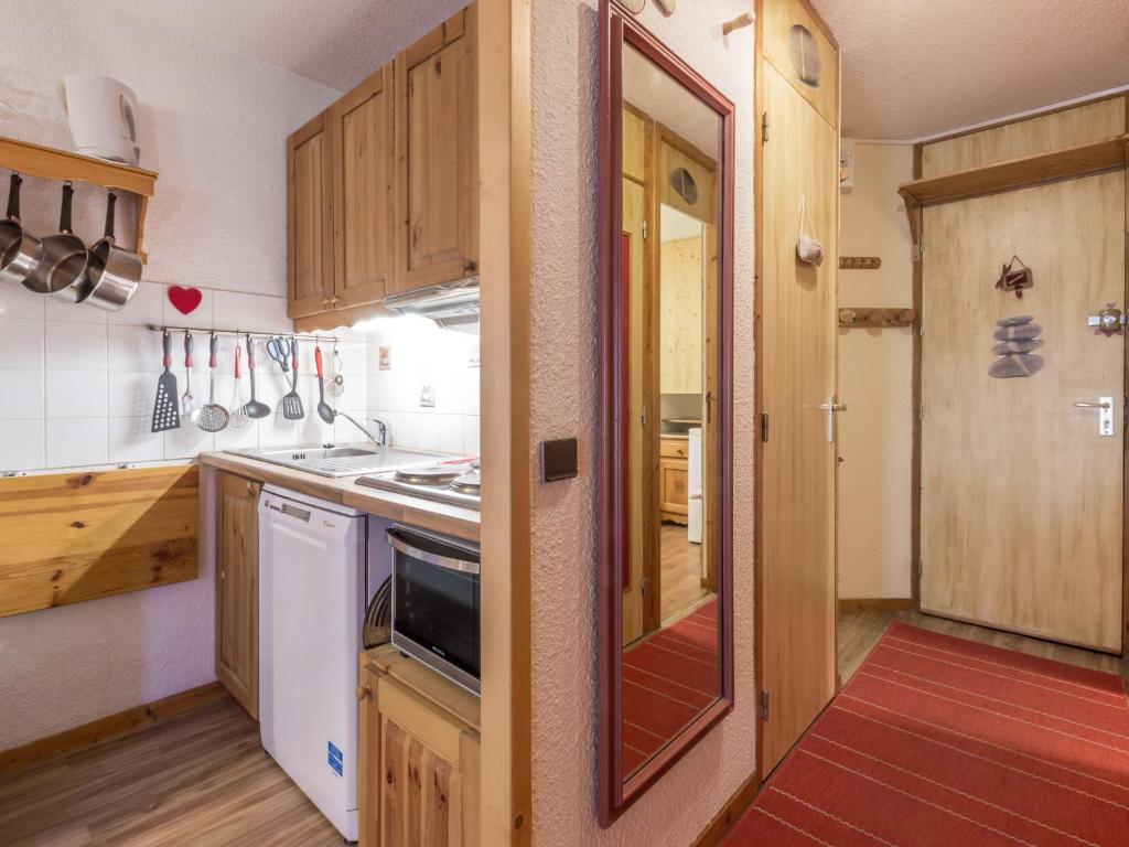 a kitchen with wooden cabinets and a white dishwasher at Appartement Valmorel, 2 pièces, 4 personnes - FR-1-356-264 in Valmorel