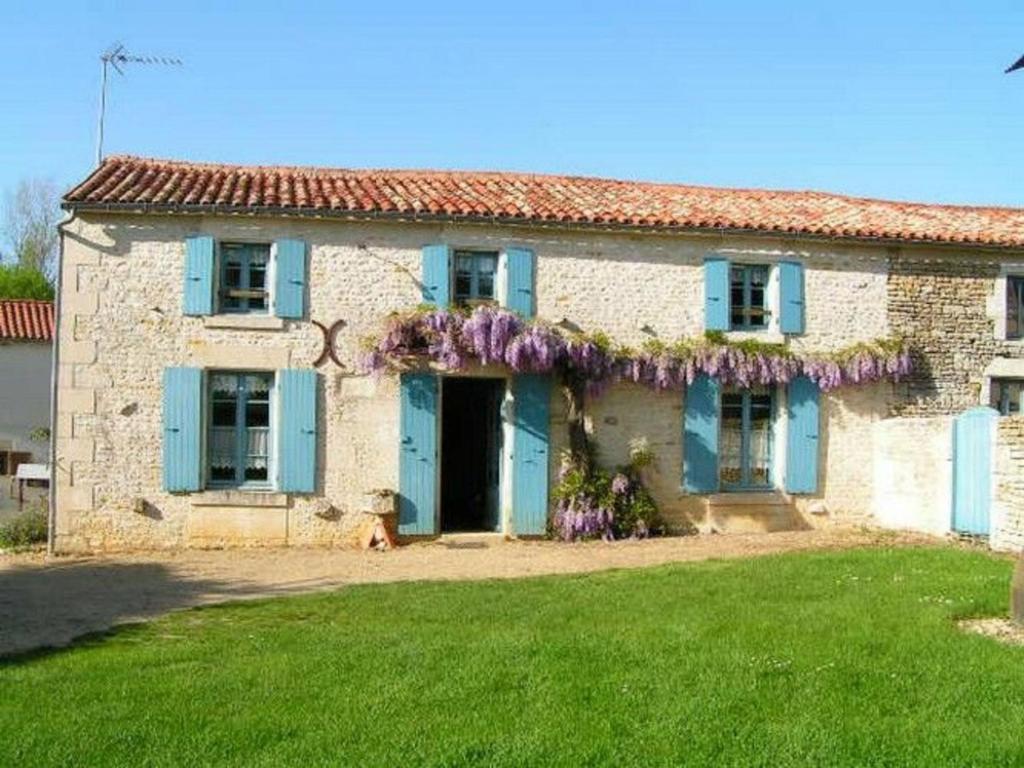 an old stone house with blue shutters and a yard at Gîte Benet, 5 pièces, 8 personnes - FR-1-426-146 in Benet