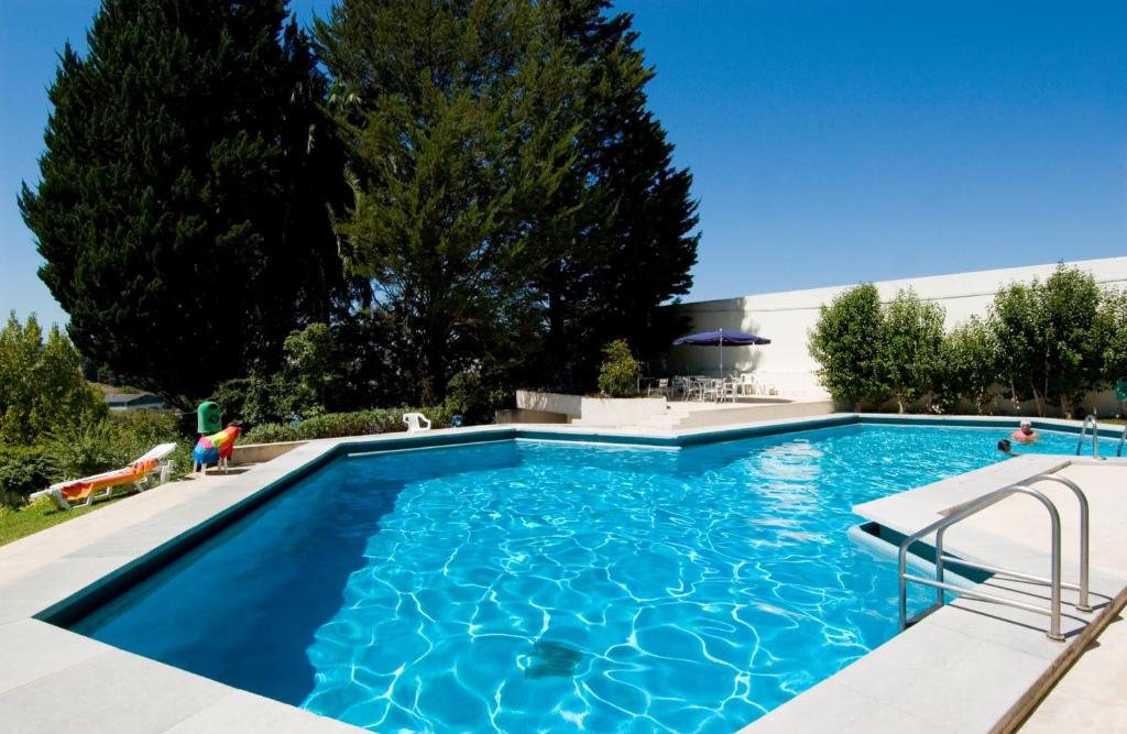 una piscina de agua azul en un patio en Eurosol Leiria & Eurosol Jardim, en Leiria