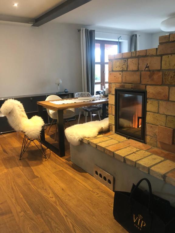 - un salon avec une cheminée, une table et des chaises dans l'établissement Ferienwohnung Design & Natur, à Ergetsweiler
