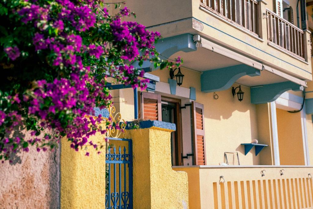 ein Gebäude mit lila Blumen davor in der Unterkunft Beautiful house in Aegina in Ägina Stadt