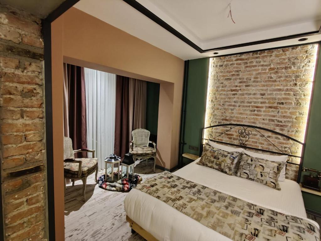 um quarto com uma cama e uma parede de tijolos em ANKA RESİDENCE em Ancara