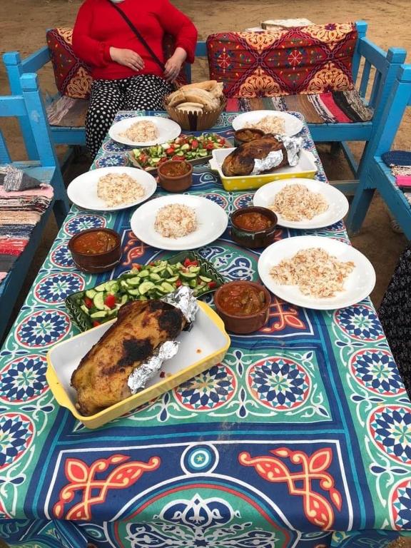 a table with plates of food on it at Nubian Farm Aswan in Aswan