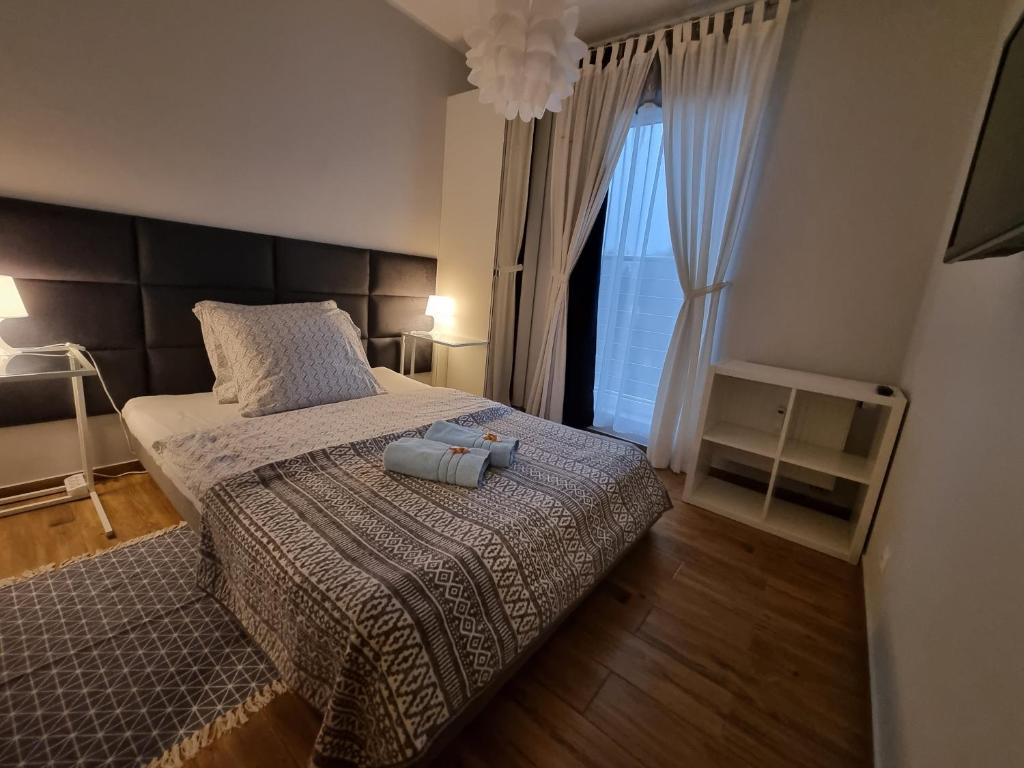 een slaapkamer met een bed met 2 kussens en een raam bij Apartament Calamo Park in Olsztyn