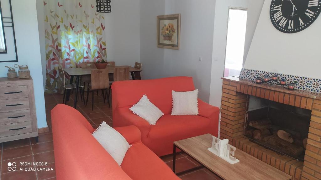 sala de estar con silla roja y chimenea en Villa Alcor, en Beas