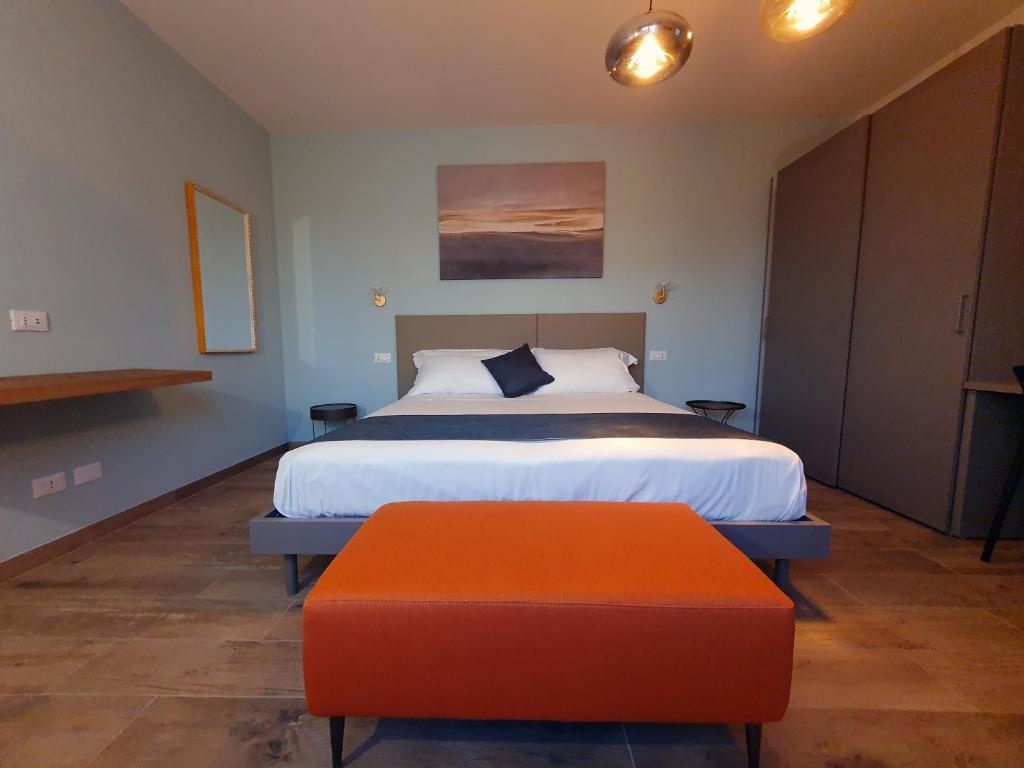 sypialnia z łóżkiem i pomarańczową otomaną w obiekcie La Lampara w Sirmione