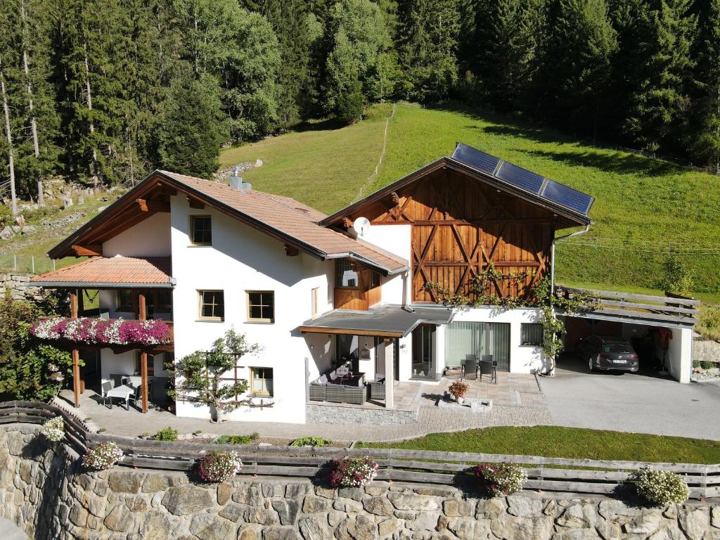 ein großes weißes Haus mit braunem Dach in der Unterkunft Haus Evelin in Sankt Leonhard im Pitztal