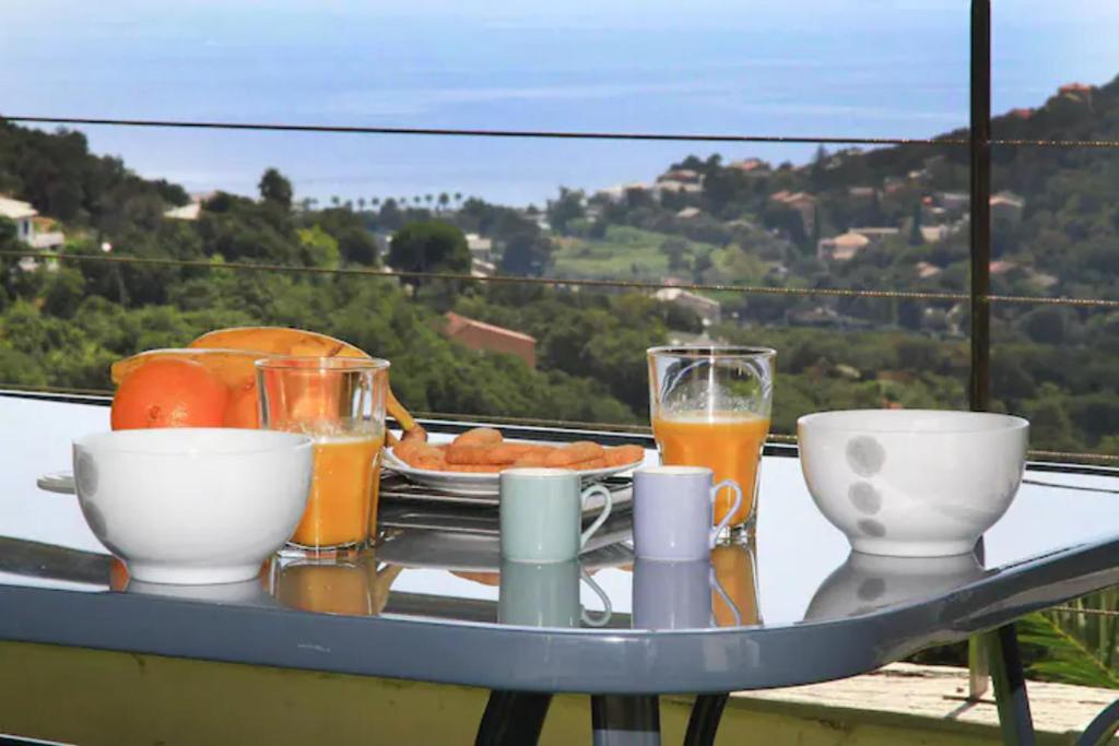 a tray of food and drinks on a table on a balcony at Cap CORSE URIBELLINU 2 formule petit déjeuner in Santa-Maria-di-Lota
