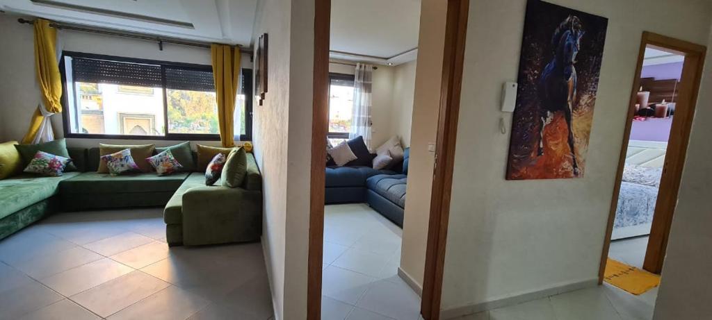 a living room with a couch and a living room with a mirror at SuperAppart KENITRA in Kenitra