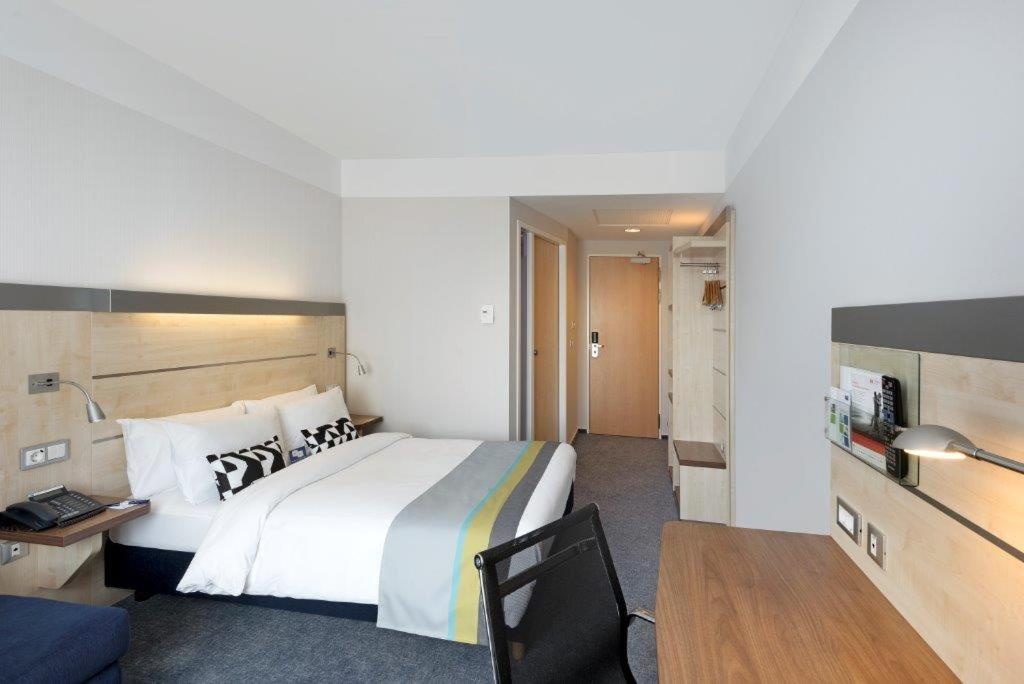 a hotel room with a bed and a desk and a chair at Holiday Inn Express Singen, an IHG Hotel in Singen