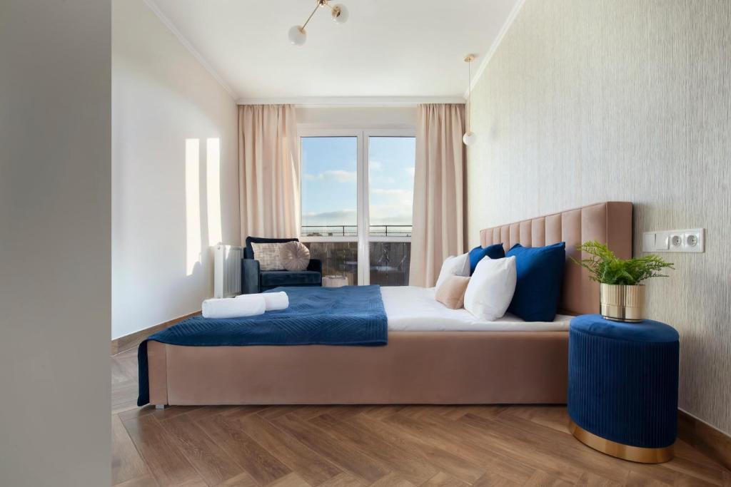 um quarto com uma cama grande com lençóis azuis e uma janela em Elite Apartments Old Town Center Premium em Gdansk