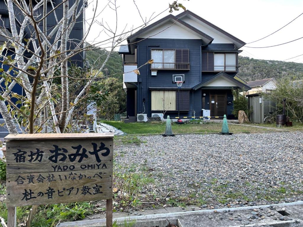 una casa azul con un cartel delante en YADO OMIYA / Vacation STAY 45672, en Kamogawa