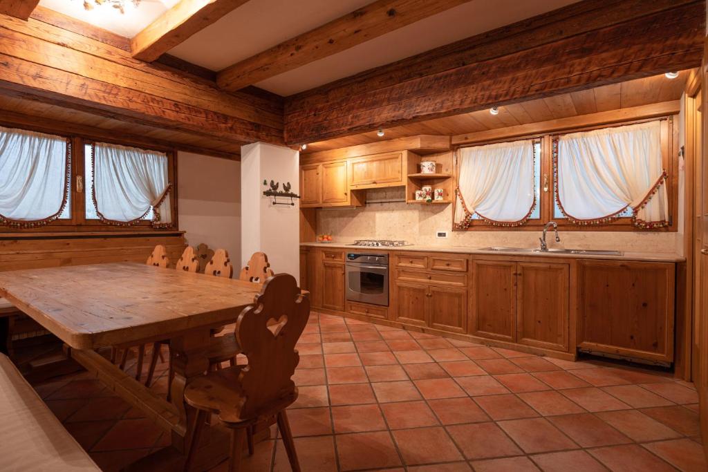 a large kitchen with a wooden table and chairs at Casa Belvedere 1 in San Vito di Cadore