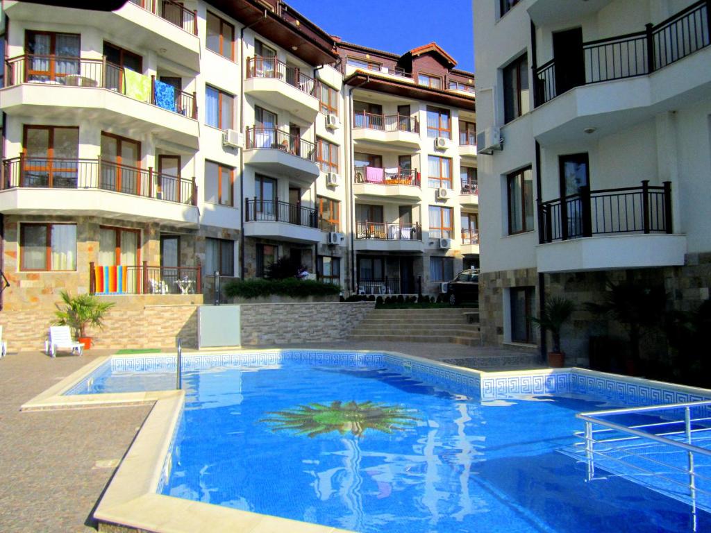 a large blue swimming pool in front of a building at Бяла Виста Бийч Апартментс B - Byala Vista Beach Apartments B in Byala