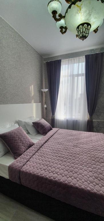 アルマヴィルにあるGostiniy Dvorのベッドルーム(紫色のベッド1台、窓付)