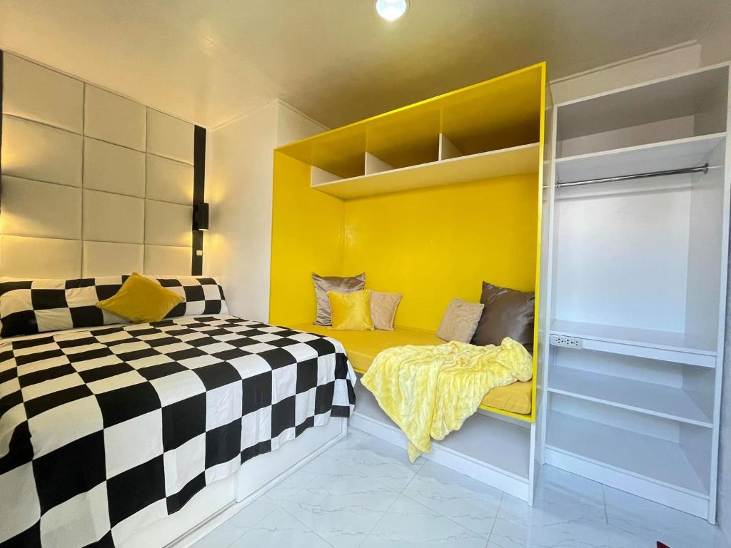 um quarto com uma cama e uma parede amarela em Malapascua Budget Inn MBI DIVE CENTER em Malapascua