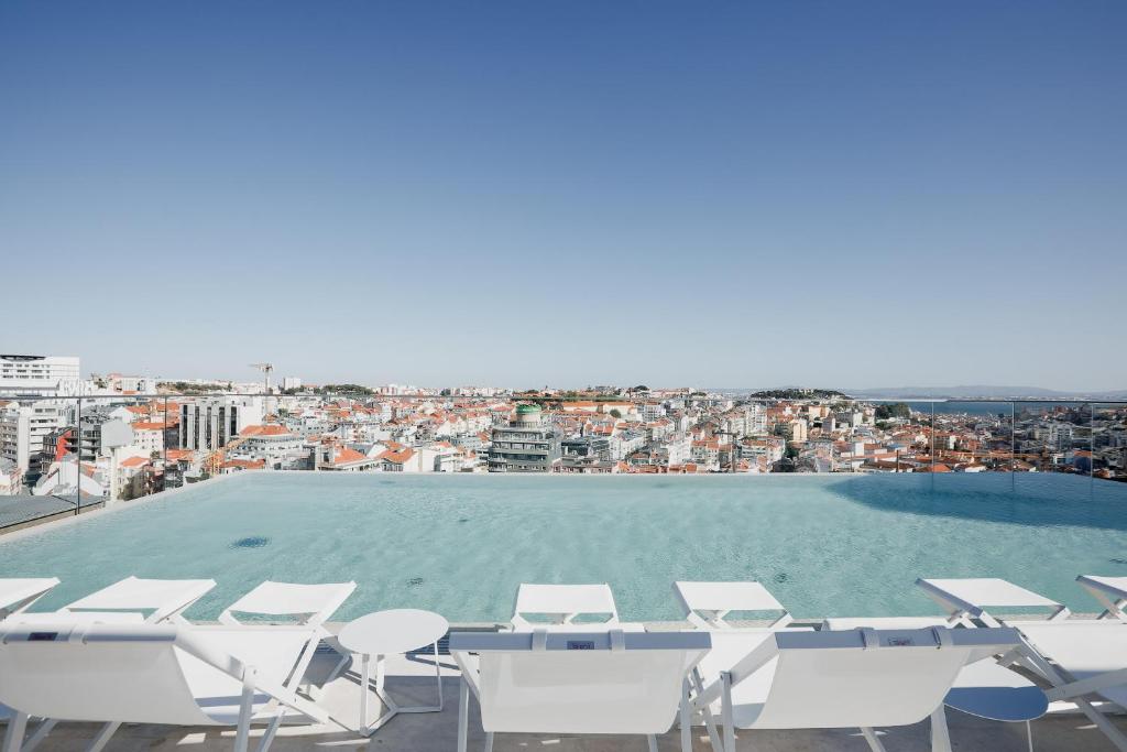 
a beach filled with lots of chairs and umbrellas at EPIC SANA Marquês Hotel in Lisbon
