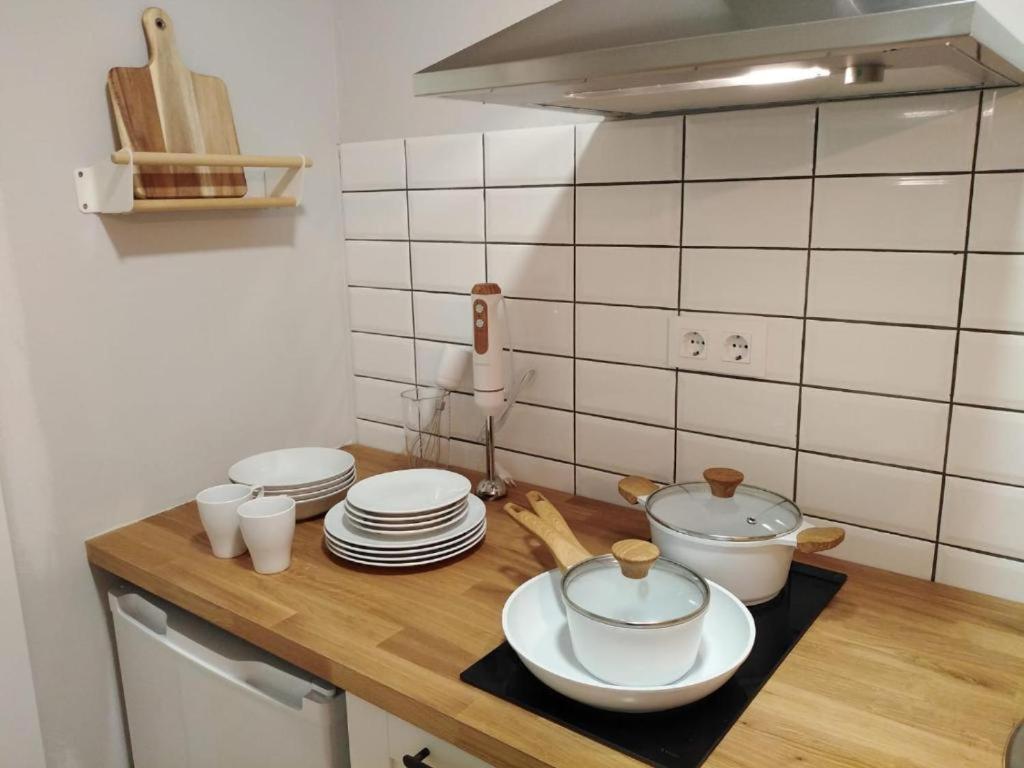 a kitchen counter with plates and pots and pans at Estudio Casco Vello in Vigo