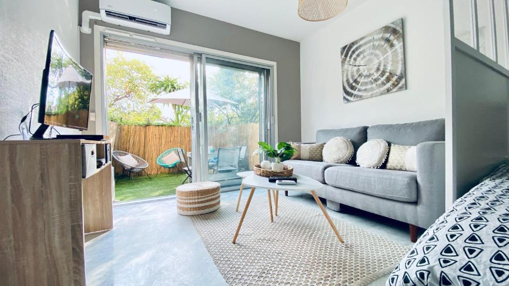 un salon avec un canapé et une table dans l'établissement Le Châtaignier Modern center parking garden, à Antibes