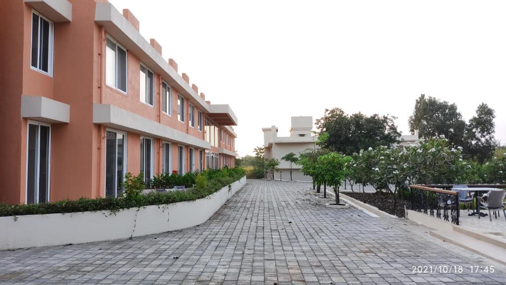 een geplaveide straat voor een gebouw bij juSTa Rudra Resort & Spa in Kolad