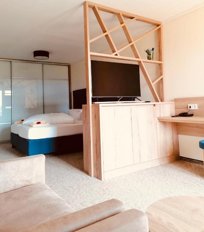 a bedroom with a bed and a tv in a room at Hotel Pachernighof in Velden am Wörthersee
