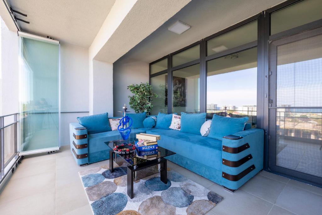 a living room with a blue couch and a table at Butterfly Homes - Apartament stil duplex Mamaia Nord in Năvodari