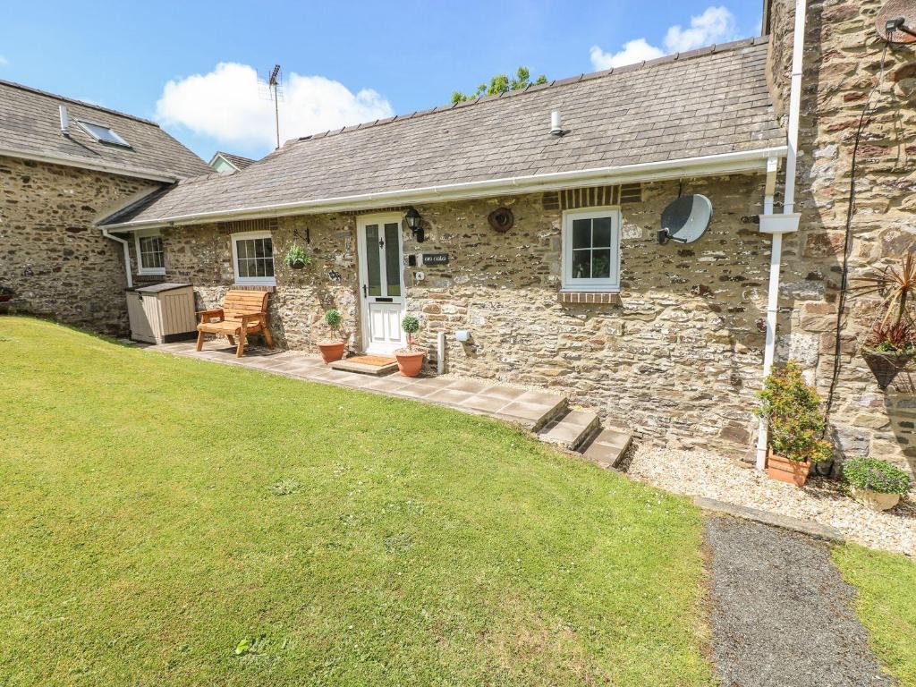 a stone house with a lawn in front of it at 4 Honeyborough Farm Cottages in Milford Haven