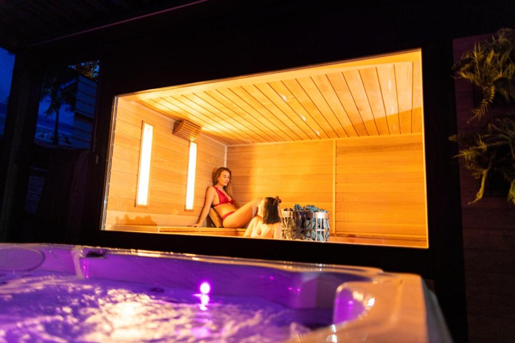 a woman sitting in a tub with a dog at Arena Deluxe & Spa in Szeged