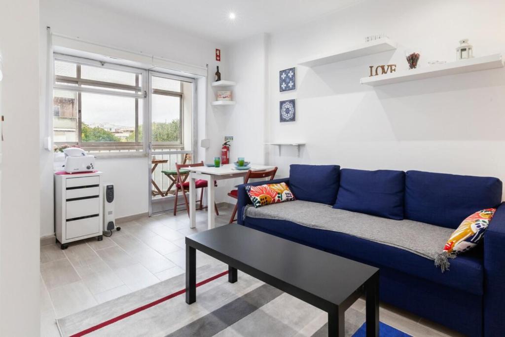 un soggiorno con divano blu e tavolo di Beautiful 1 Bedroom Apartment near Benfica a Lisbona