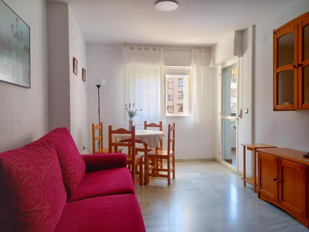 - un salon avec un canapé rouge et une table dans l'établissement Apartamento Hibisco , Primera Línea de Playa, à Almuñécar