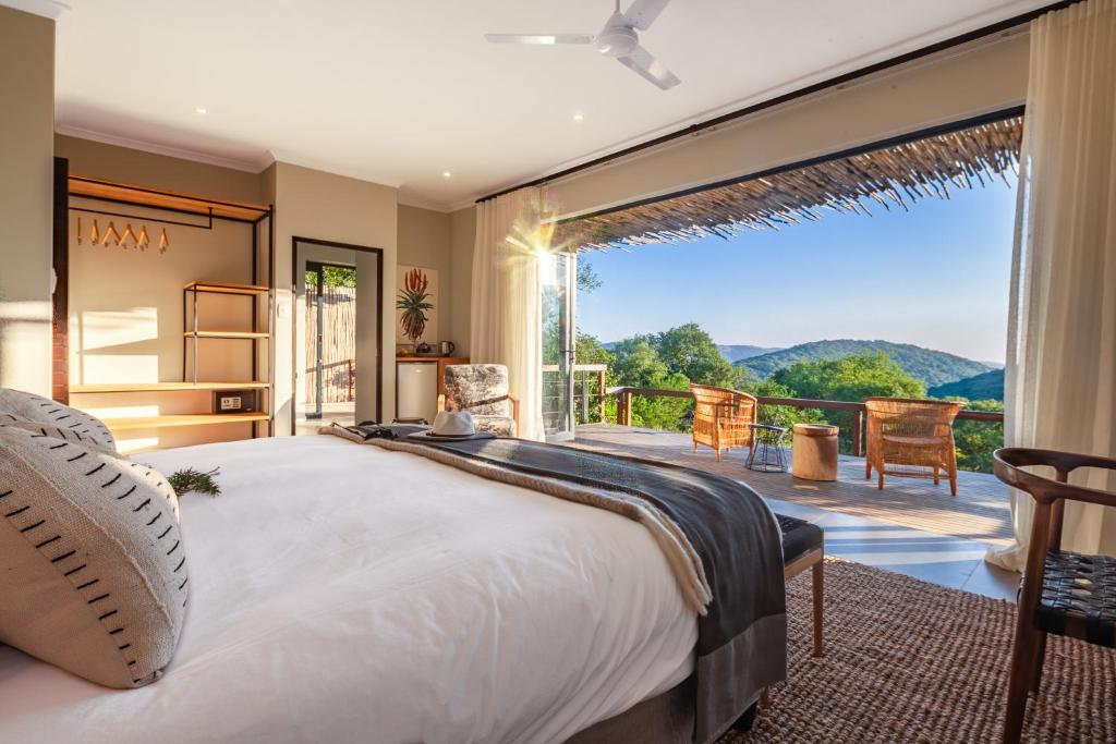 - une chambre avec un grand lit et une grande fenêtre dans l'établissement Sungulwane Private Game Lodge, à Hluhluwe