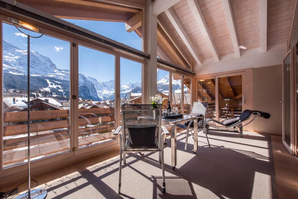ヴェンゲンにあるChalet Schneehoren Penthouseの山の景色を望む客室で、デスクが備わります。