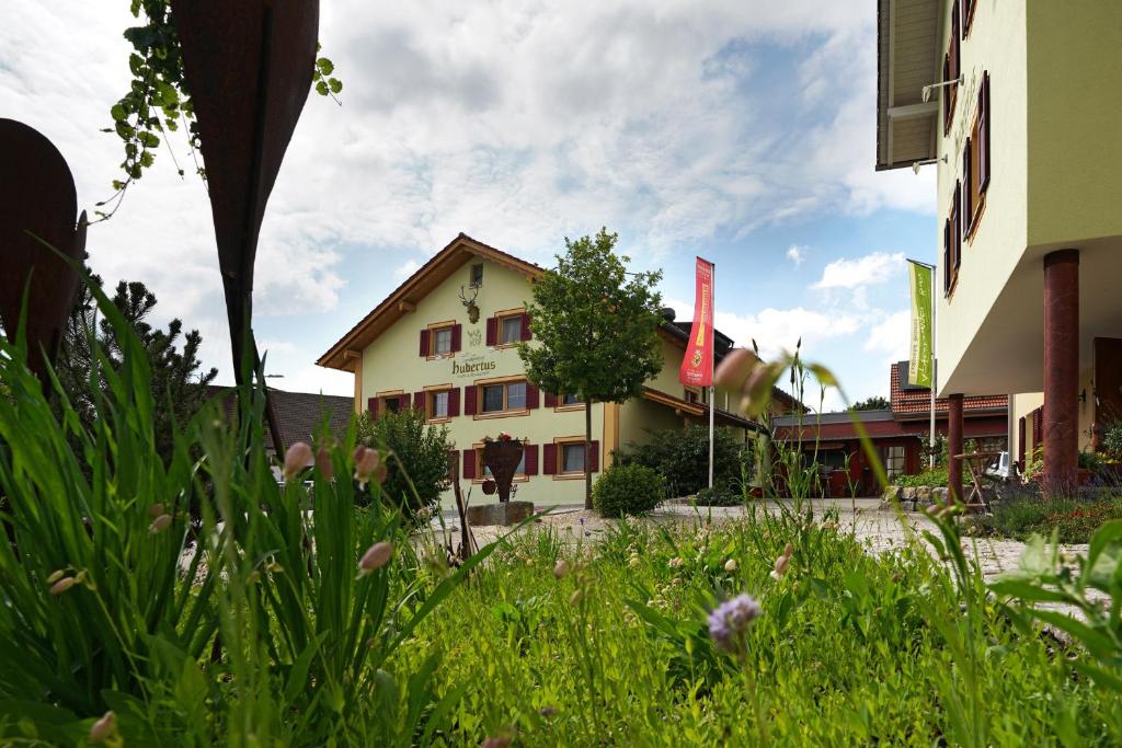 ein Gebäude inmitten eines Grasfeldes in der Unterkunft Landgasthof Hubertus - Braugasthof und Wellnesshotel im Allgäu in Apfeltrang